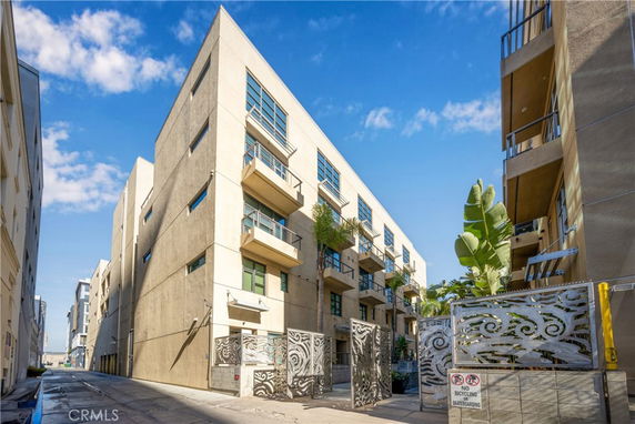 Front view of a modern multi-story apartment building with balconies.
