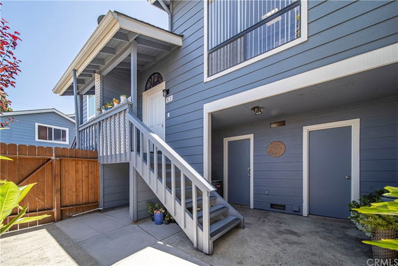 Front view of a two-story house with a staircase leading to the main entrance.