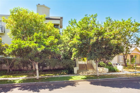 Front view of a multi-story building with trees in front.