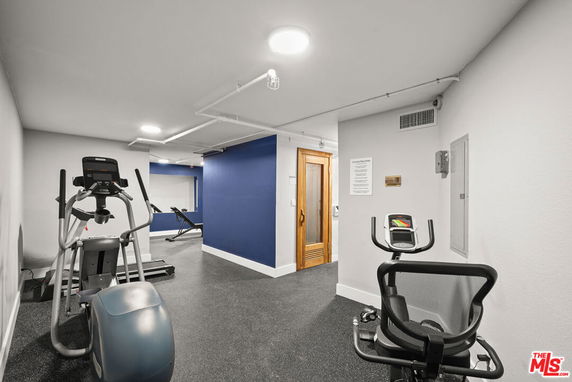 Interior view of a fitness room with exercise equipment and a sauna.