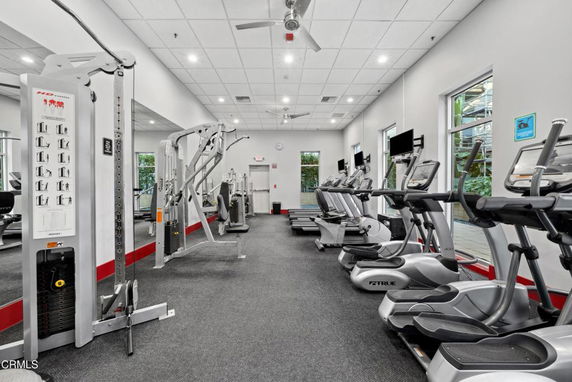 Indoor gym area with exercise equipment including treadmills and weight machines.