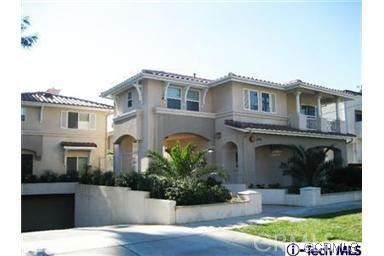 Front view of a two-story house with multiple balconies and a garage.