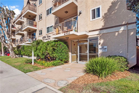Front view of a multi-story apartment building with balconies.