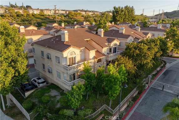 Front view of a multi-story residential building with multiple balconies and a tiled roof.