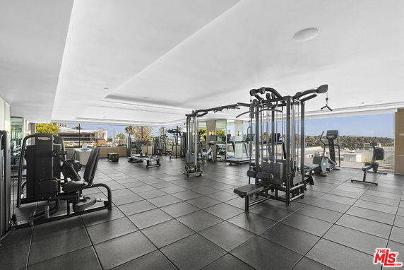 Indoor gym area with various exercise machines and equipment.