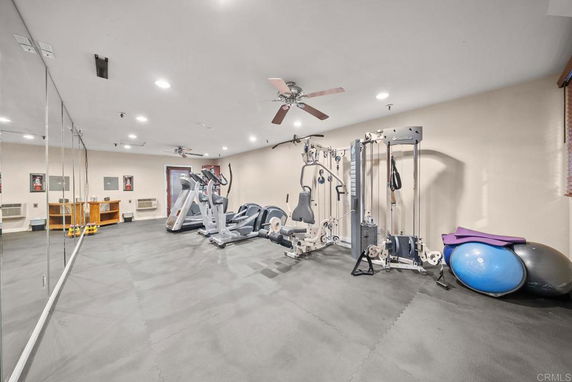 Indoor gym area with exercise equipment including treadmills, weight machines, and fitness balls.