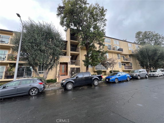 Front view of a multi-story apartment building with balconies.