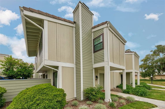 Front view of a modern two-story house with a sloped roof and chimney.