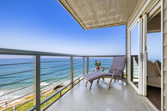 Balcony area with lounge chairs overlooking the ocean.