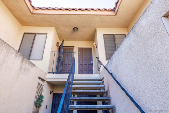 Front view of an apartment entrance with stairs leading to a doorway.