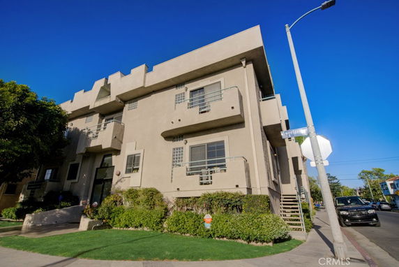 Front view of a multi-story building with balconies and modern design elements.