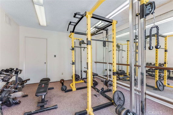 Indoor gym area with weightlifting equipment and mirrors.