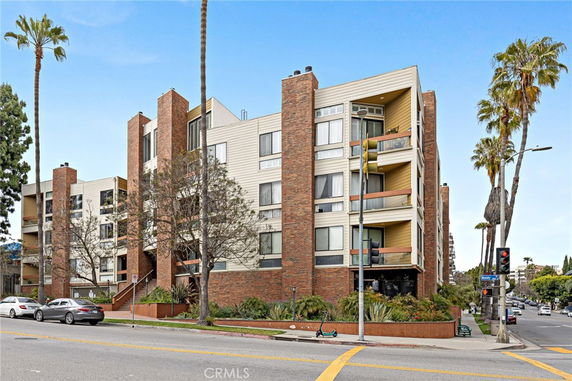 Front view of a multi-story apartment building with brick and beige exterior.