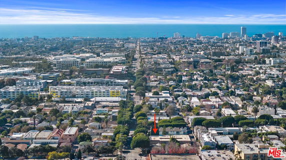 Wide-angle view of a cityscape with buildings and the ocean in the background.