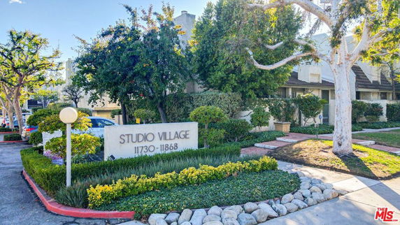 Front view of a residential complex labeled 'Studio Village' with multiple units.