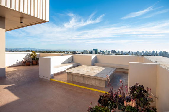 Rooftop area with seating and a view of the city skyline.