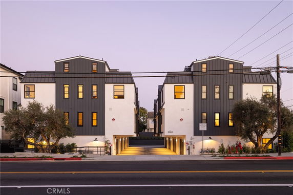 Front view of a modern multi-story building with large windows and a central entrance.