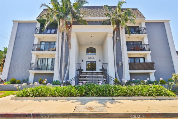 Front view of a multi-story apartment building with balconies.