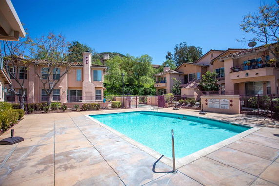 Outdoor swimming pool area surrounded by residential buildings.