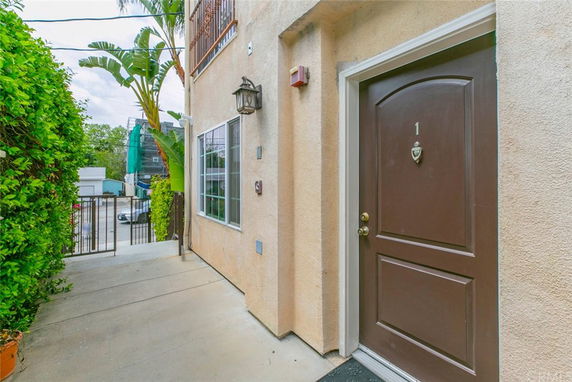 Entrance view of a house with a brown door marked '1' and a window nearby.