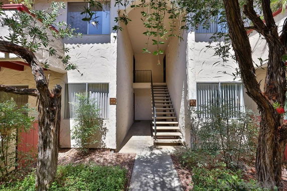 Front view of a multi-story building with an external staircase leading to the upper level.