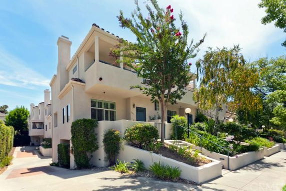 Front view of a multi-story house with balconies and stairs leading up to the entrance.