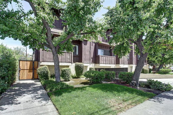 Front view of a two-story house with wooden panels and small balconies.