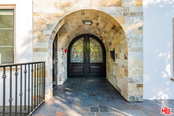 Front view of a stone-arched entrance with decorative double doors.