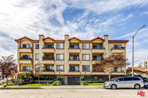Front view of a multi-story apartment building with balconies.