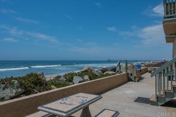 View of a seaside area with a walkway and steps leading to the beach.