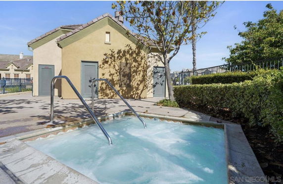 Outdoor view of a small swimming pool or hot tub next to a small building.