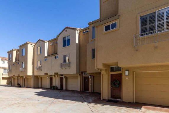 Front view of multi-story townhouses with garages on the ground floor.