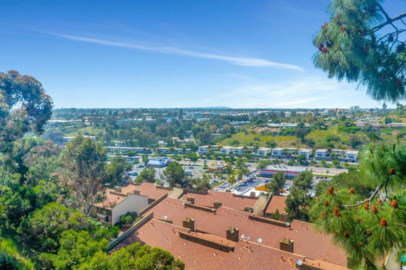 Panoramic view overlooking a residential area with buildings and surrounding greenery.