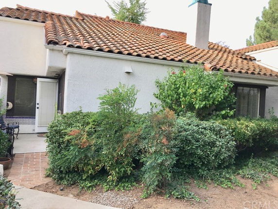 Front view of a house with a red tiled roof and chimney.
