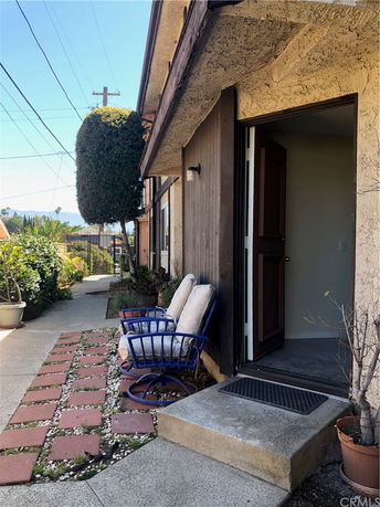 Front view of a house entrance with a small outdoor seating area.