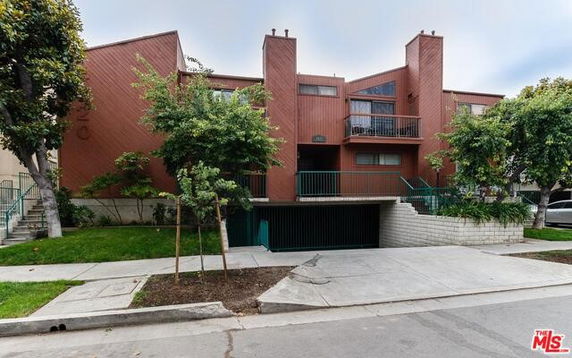 Front view of a multi-story residential building with a parking entrance.