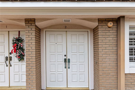 Front view of a house entrance with double doors and decorative wreath.