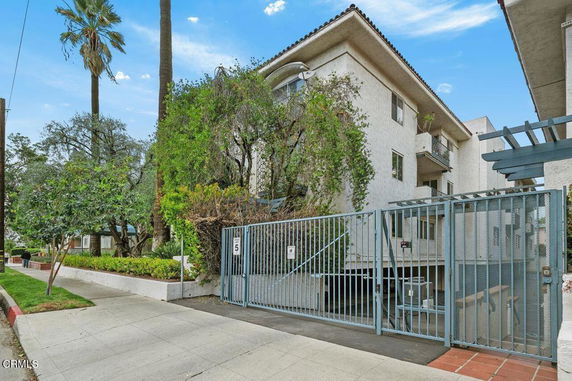 Front view of a multi-story building with gated entry.