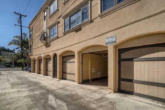 Outdoor parking area with multiple garage entrances in a building.