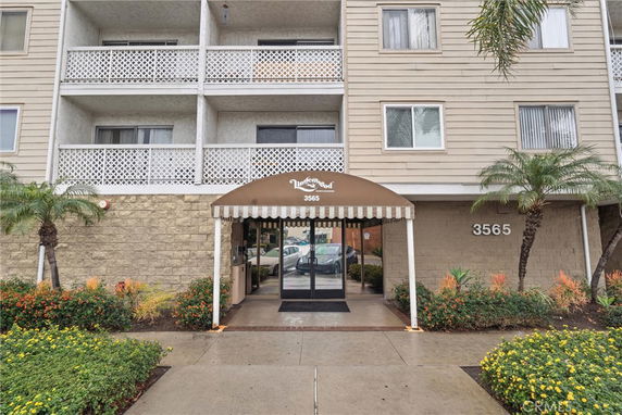 Front view of a multi-story building with balconies and an entrance canopy.