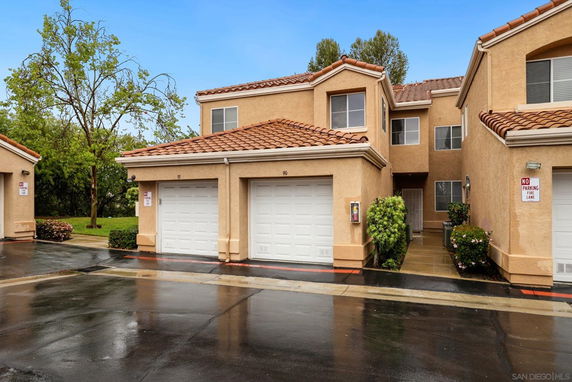 Front view of a two-story building with attached garages and tiled roofs.