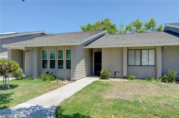 Front view of a single-story house with a sloped roof and large windows.