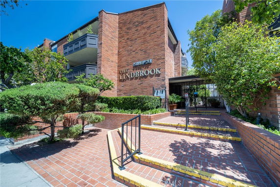 Front view of a multi-story brick building with balconies and an entrance marked by 'The Lindbrook'.