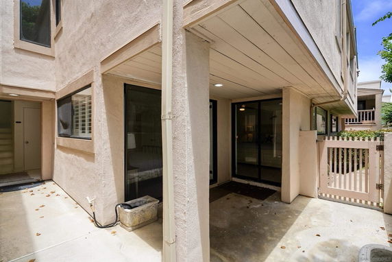 Exterior view of a residential area including a multi-story building with windows and a gated entrance.