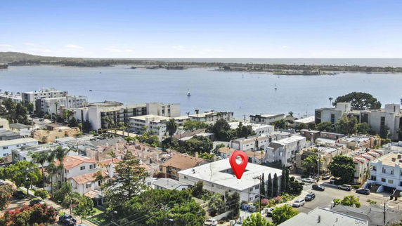 Panoramic view of a coastal residential area with buildings near the water.