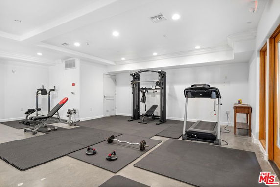 Indoor gym area with exercise equipment including a treadmill, weight bench, and cable machine.