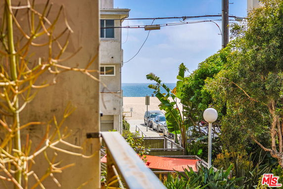 View of a beach and ocean from between buildings.