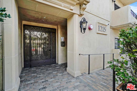 Front view of a building with an ornate metal gate and a light fixture.