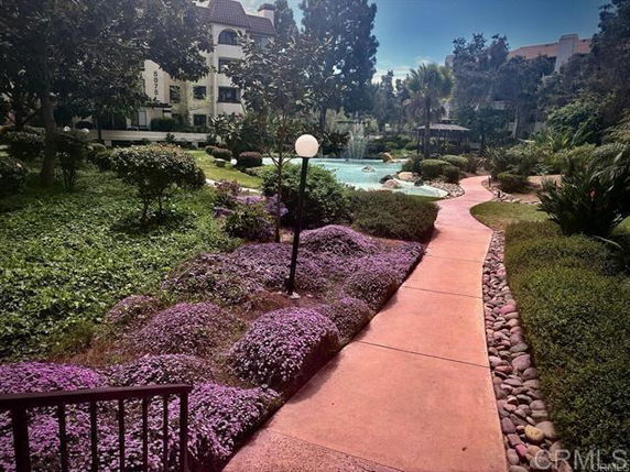 Garden view with pathway and residential buildings in the background.