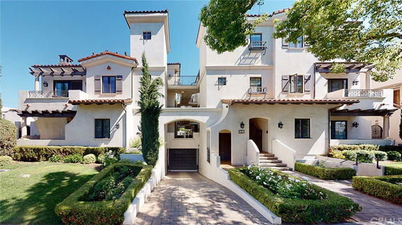 Front view of a multi-story house with a Mediterranean style.